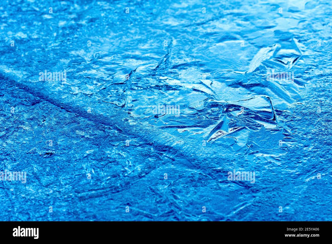 Gros plan montrant la surface fracturée d'une feuille de glace, où elle s'est partiellement décongelée et fissurée avant de la redégeler. Banque D'Images