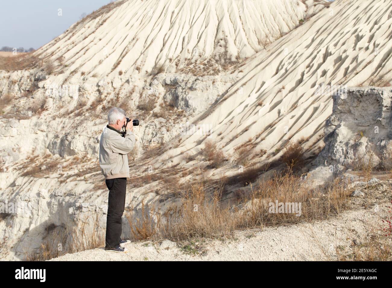Le photographe prend des photos de paysage. Il est dans une vieille carrière abandonnée. Banque D'Images