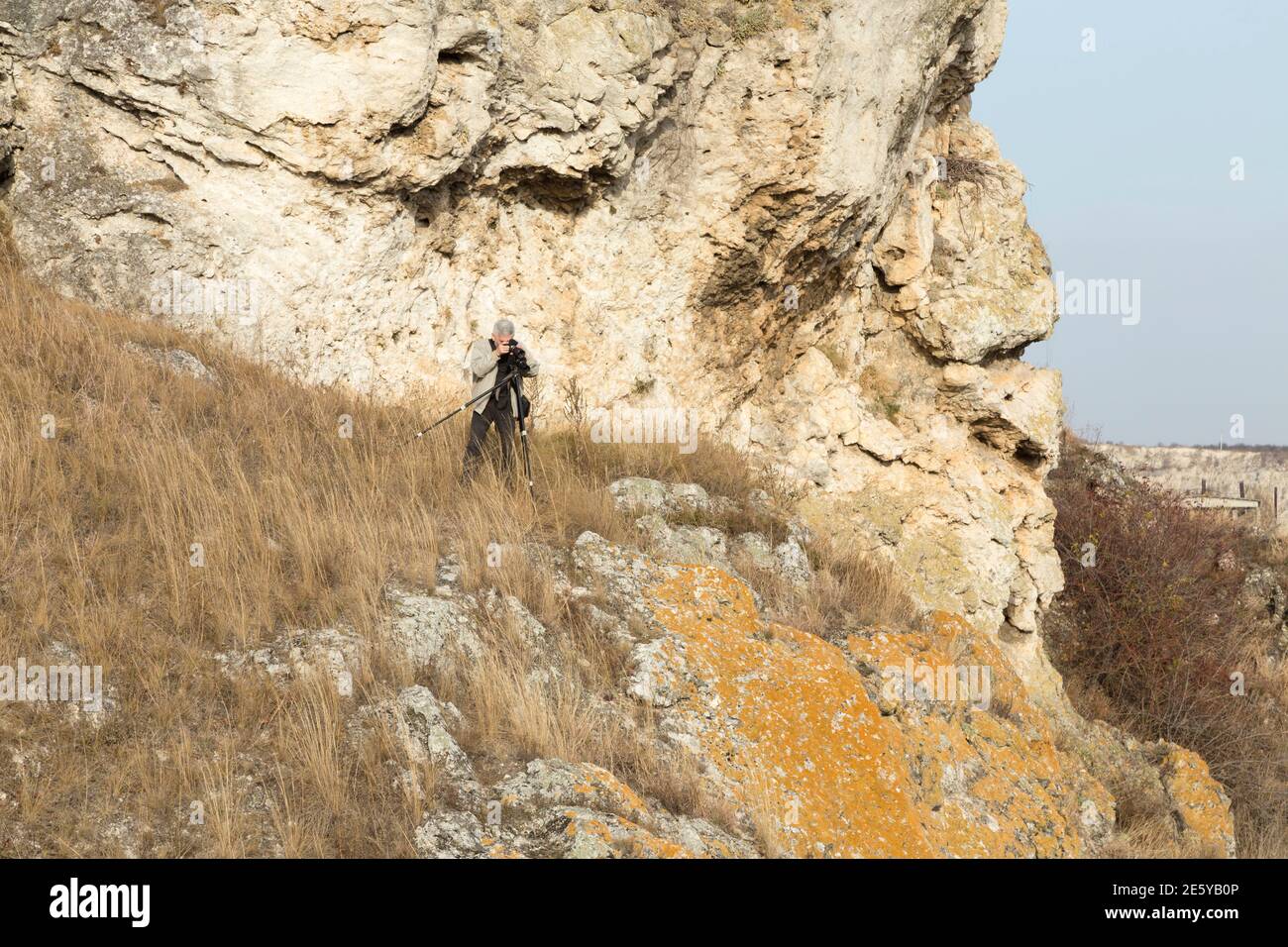 Le photographe prend des photos de paysage. Il est situé à côté de la falaise. Banque D'Images