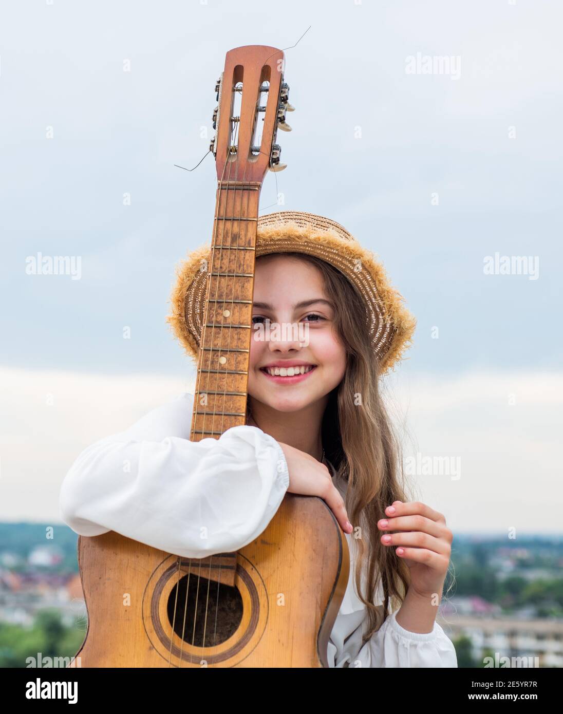 enfant fille élégante jouant de la guitare en plein air, musique country. Banque D'Images