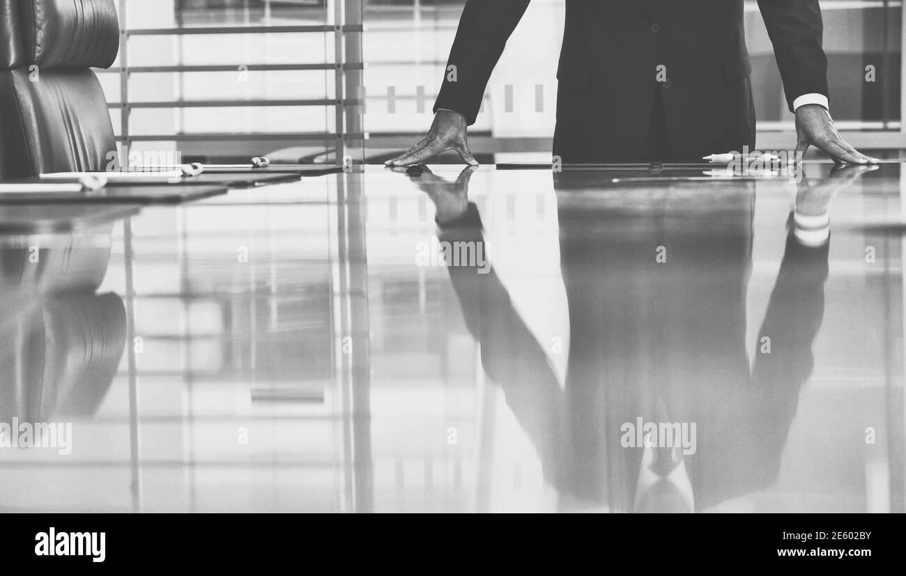 Photo en noir et blanc d'un homme d'affaires debout table de conférence Banque D'Images
