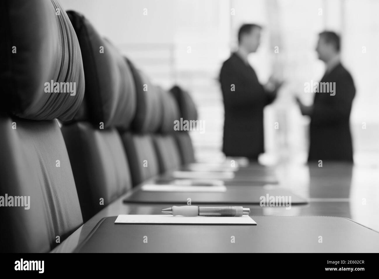 Photo en noir et blanc des hommes d'affaires qui parlent dans la salle de conférence Banque D'Images