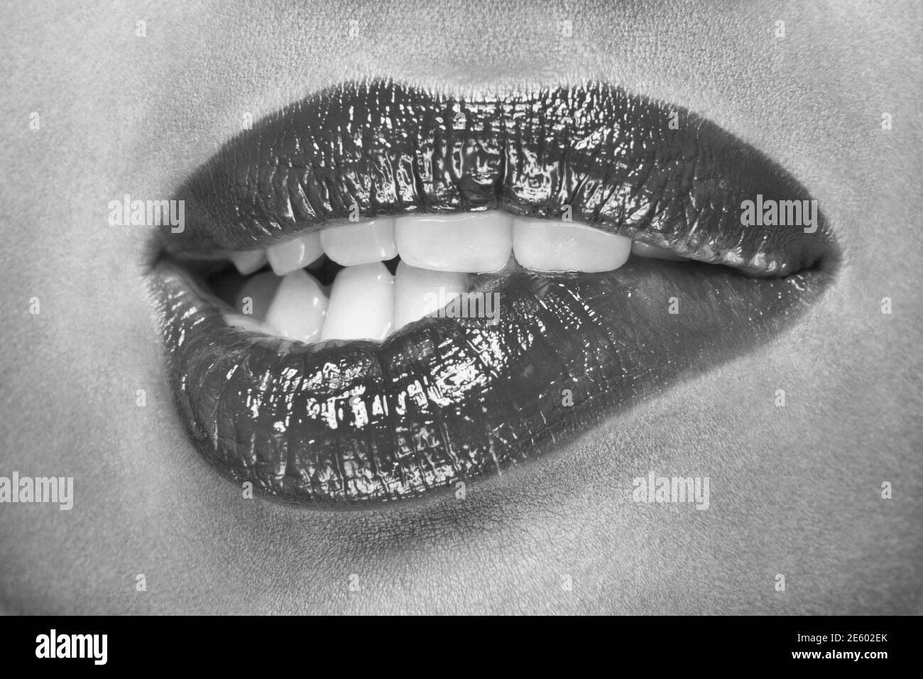 Photo noire et blanche de la femme qui mord les lèvres Banque D'Images