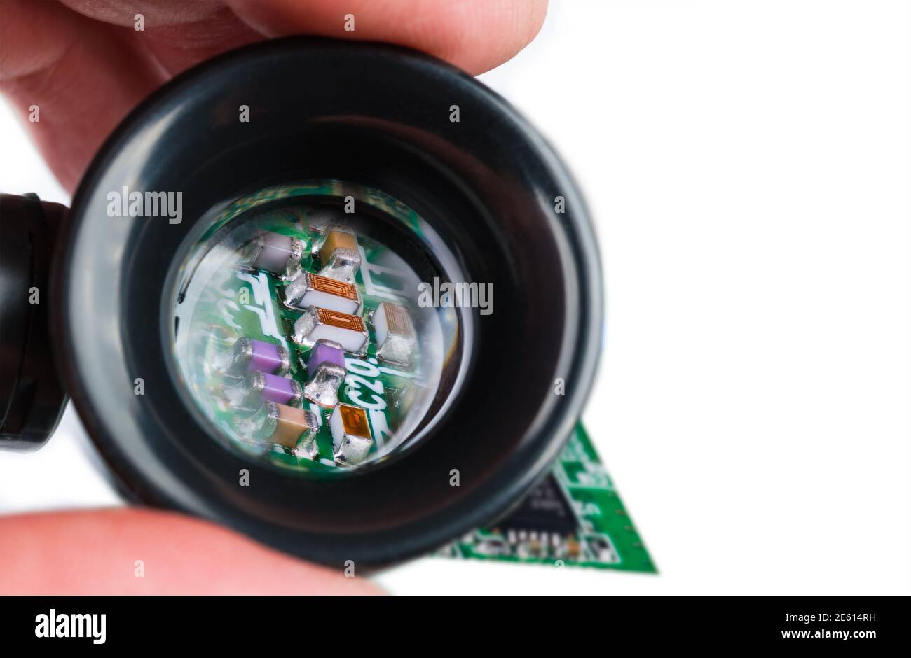 Inductances, résistances et condensateurs miniatures en loupe sur fond blanc. Composants électroniques semi-conducteurs sur carte de circuit imprimé verte. Tech. Banque D'Images