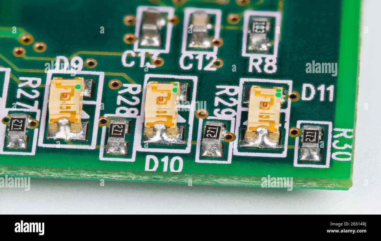 Petites diodes électroluminescentes sur la carte de circuit imprimé. Technologie de montage en surface. Voyants LED jaunes transparents, condensateurs et résistances sur ci verte. Banque D'Images