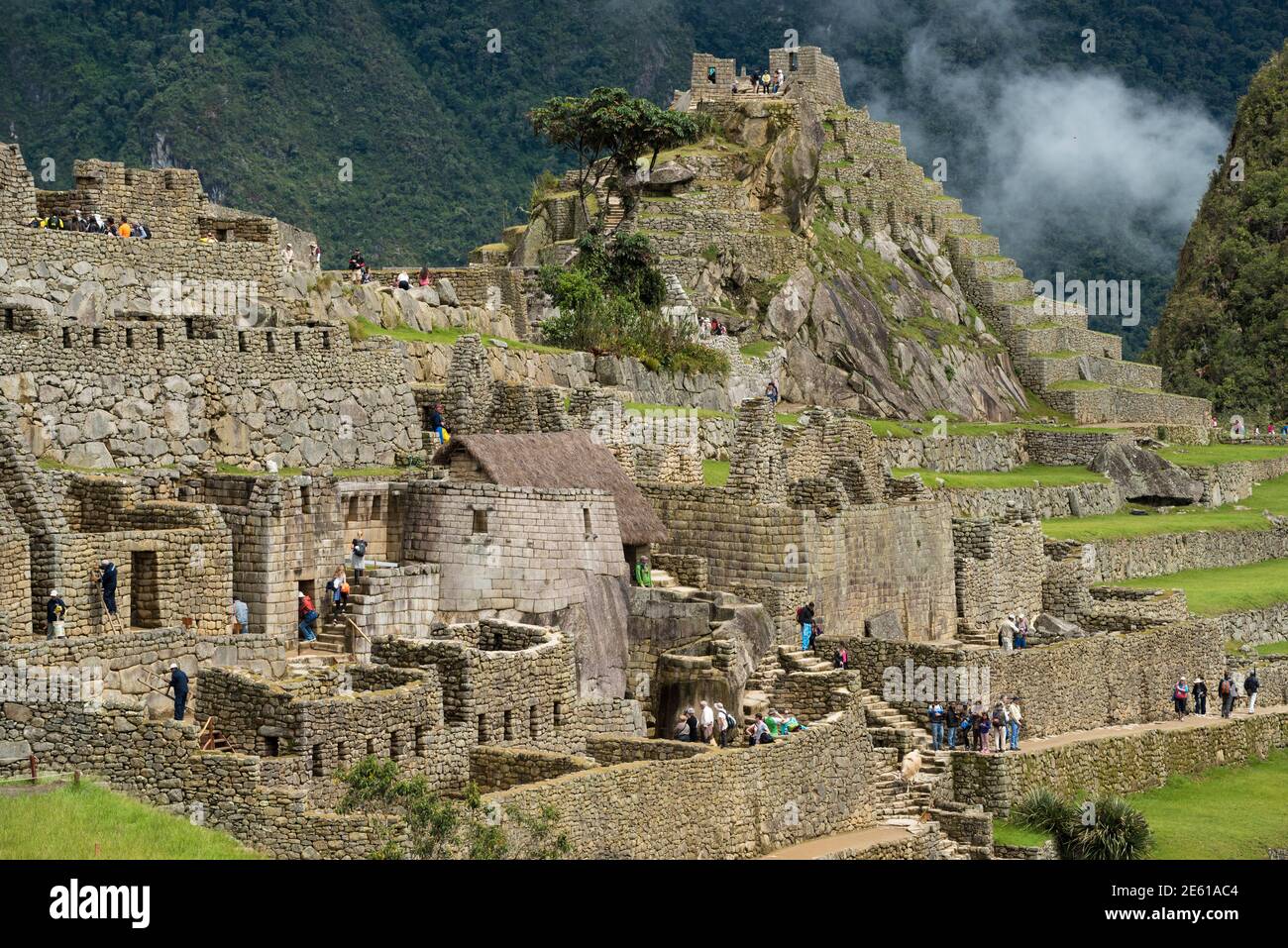 Visiteurs visitant les ruines de l'Inca à Machu Picchu, Pérou. Banque D'Images