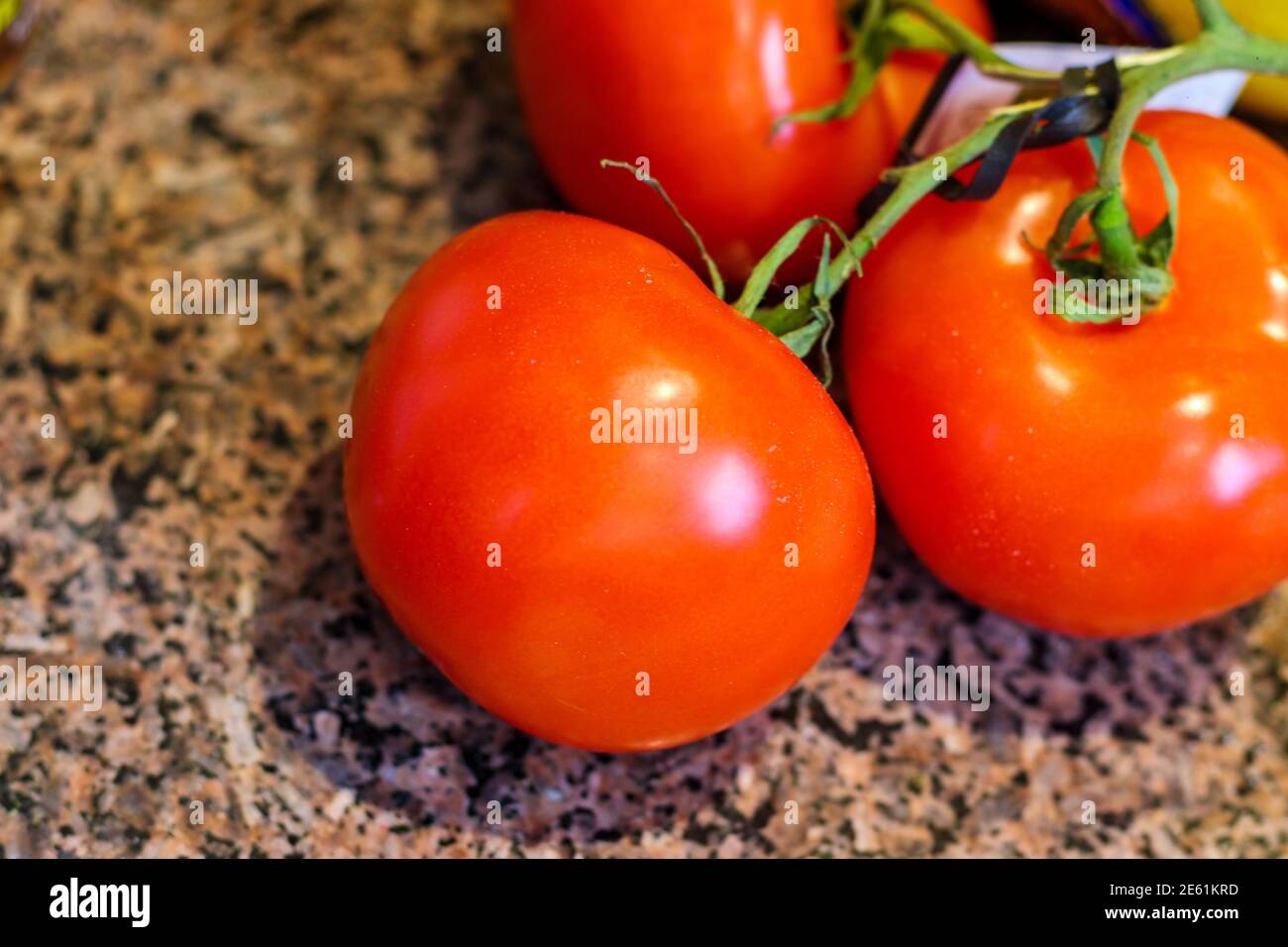 Tomates rouges fraîches sur la vigne vue de près un comptoir en granit Banque D'Images