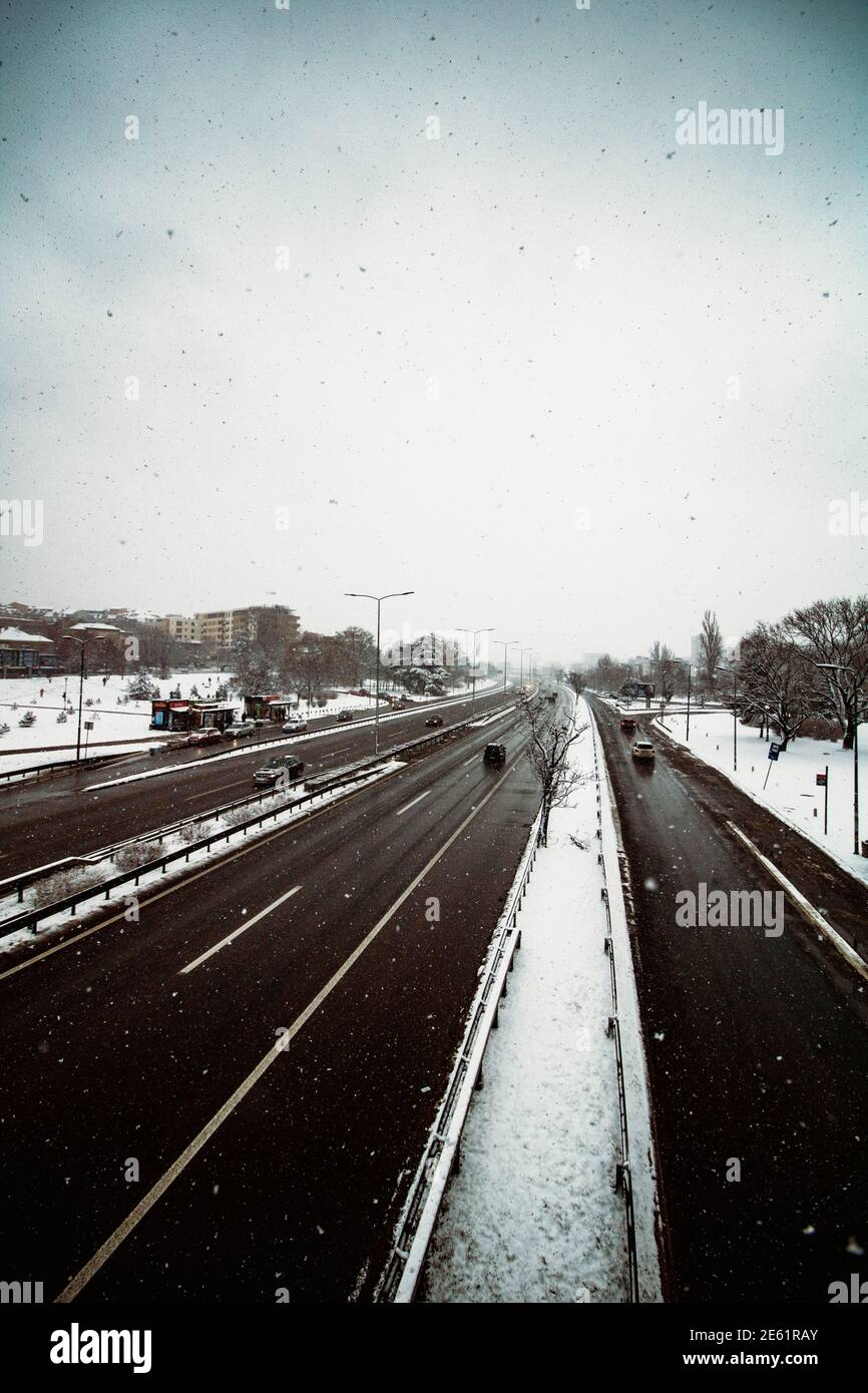 Autoroute photographiée depuis un pont, paysage urbain d'hiver avec de la neige tombant sur l'autoroute Banque D'Images