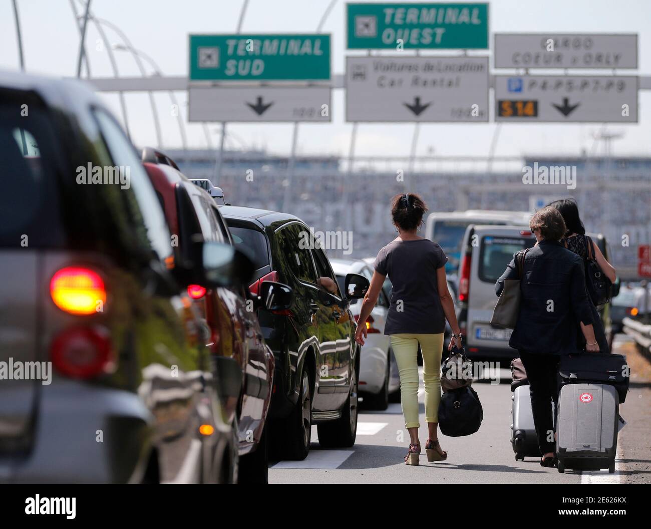Les passagers traînent leurs valises en direction de l'aéroport d'Orly,  tandis que des chauffeurs de taxi en grève bloquent les routes d'accès au  sud de Paris, en France, lors d'une manifestation nationale