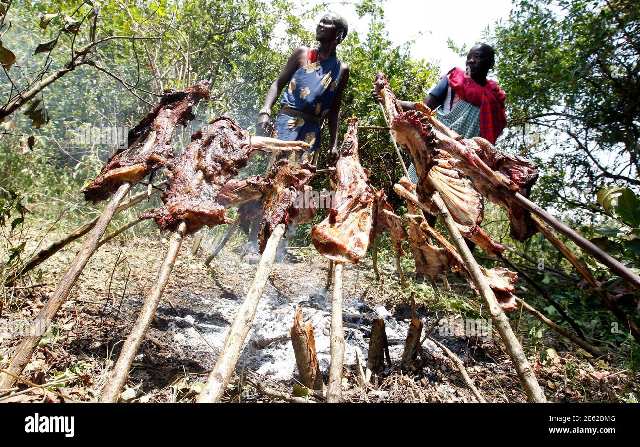 Les anciens de Maasai torréfient la viande lorsqu'ils participent à la préparation de 'Entoto', une cérémonie traditionnelle de l'âge à Olkerin Manyatta, dans le comté de Narok, à environ 108 km (67 miles) à l'ouest de la capitale du Kenya Nairobi, le 18 mars 2012. REUTERS/Thomas Mukoya (KENYA - Tags: SOCIÉTÉ) Banque D'Images