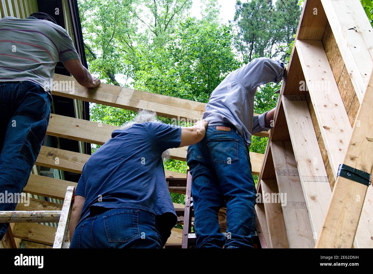 Les gens qui font des travaux de construction, l'un tenant l'autre pour le soutien Banque D'Images