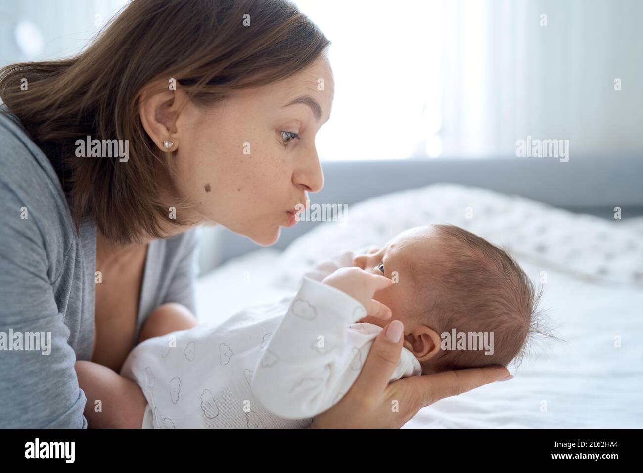 Gros Plan D Un Bebe Garcon D Un Mois Allonge Sur Le Lit Et Jouant Avec Sa Maman Maman Qui Parle A Son Fils Et Le Calin Photo Stock Alamy