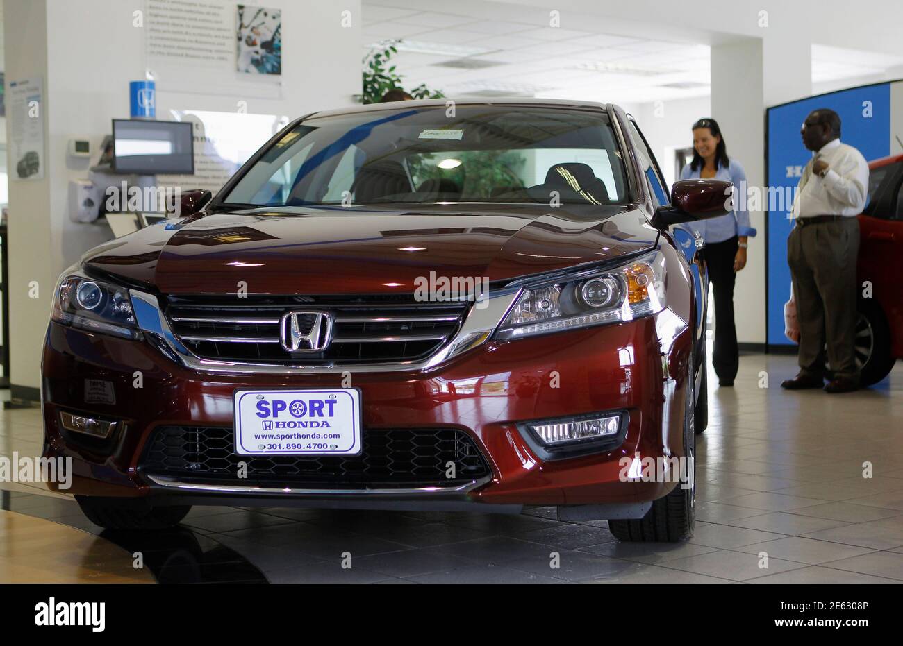 Sales personnel at Sport Honda look over the first 2013 Honda 