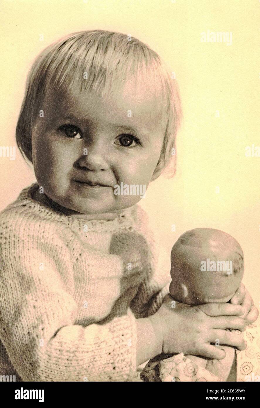 ZWICKAU, ALLEMAGNE DE L'EST - VERS 1970s: La photo rétro montre bébé fille  tient dolly. Photo de studio. Photo noir et blanc.1970s Photo Stock - Alamy