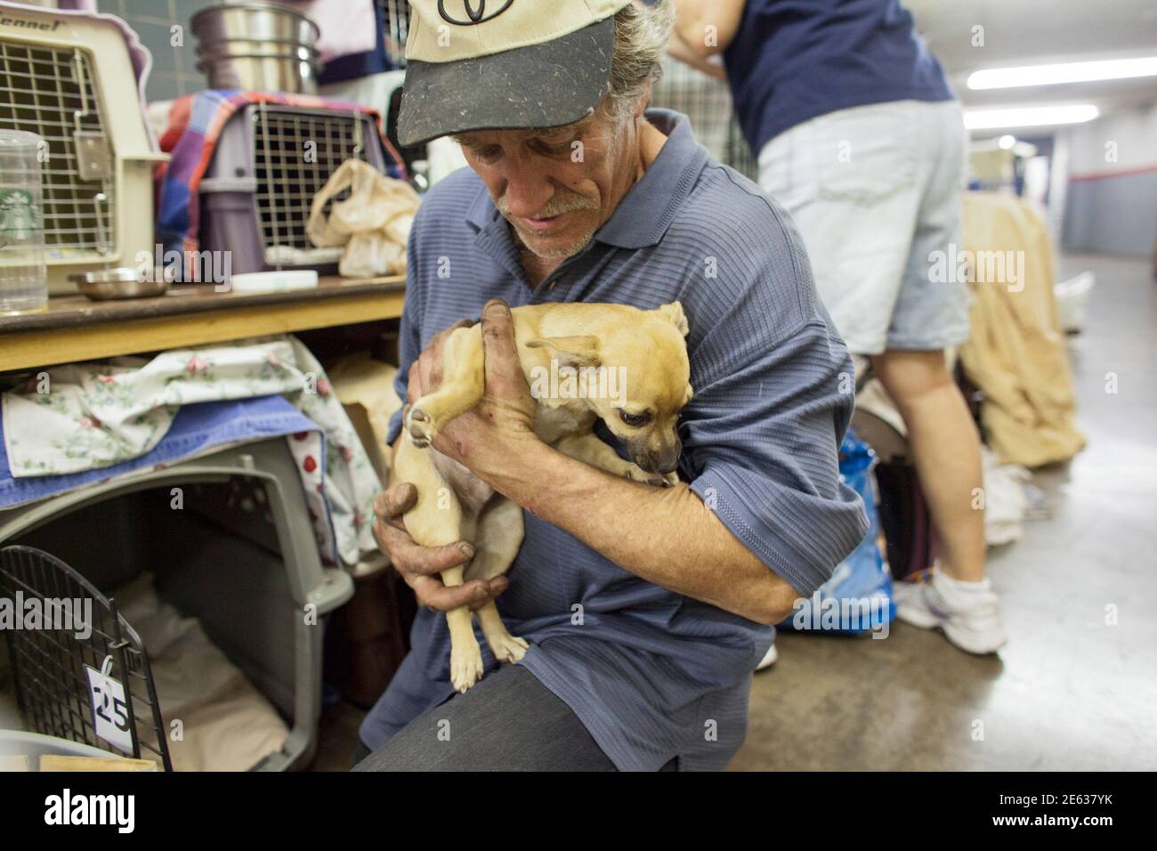 John Conner, whose wife is a veteran, holds his dog as he waits for  veterinarian care at the 13th annual StandDown in Phoenix, Arizona February  14, 2014. More than 1500 homeless veterans