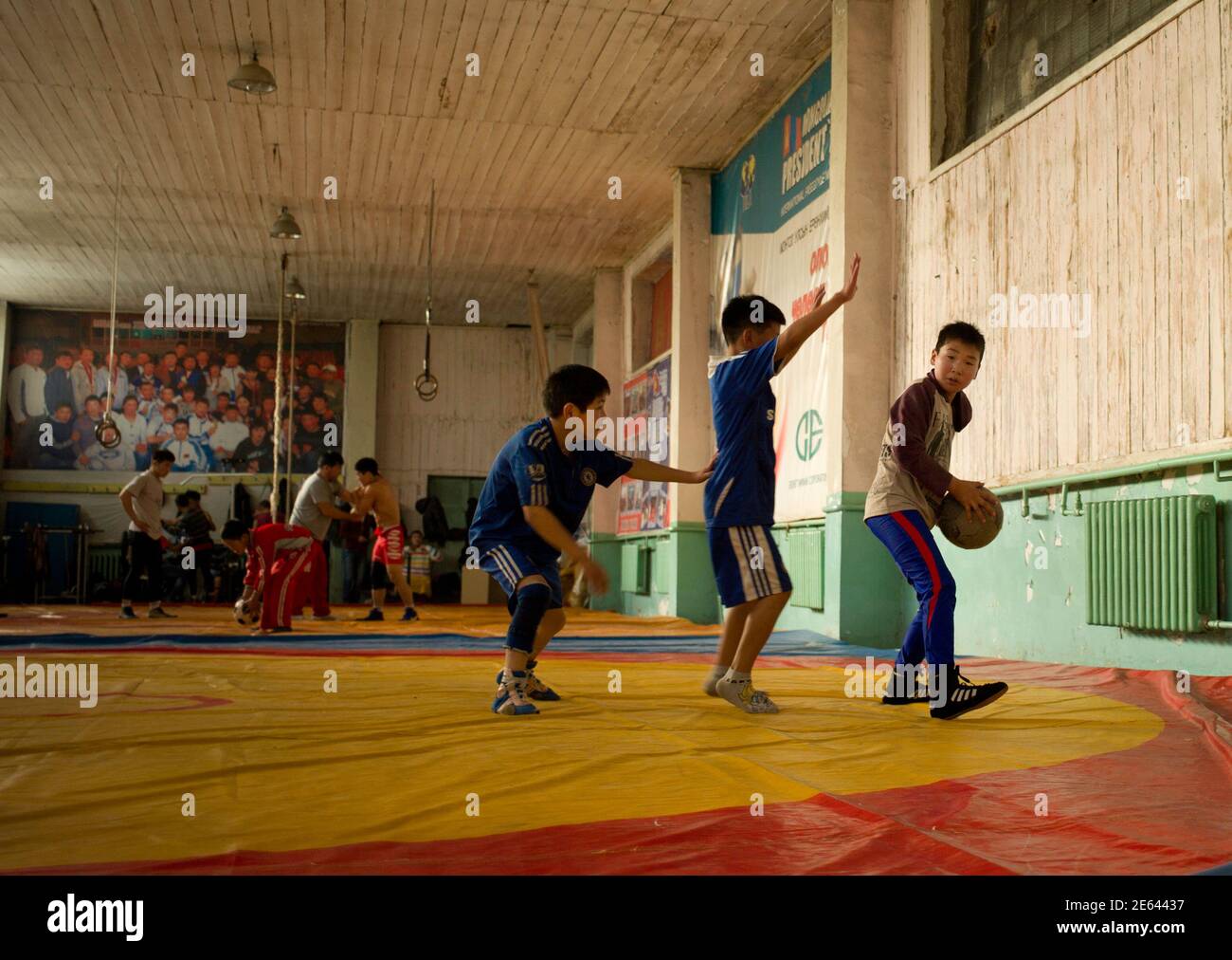 Children play basketball at a gym which they share with Mongolia's Olympic  freestyle 60kg wrestler Mandakhnaran Ganzorig in Ulan Batur, October 27,  2011. While the elite of the sporting world tune up