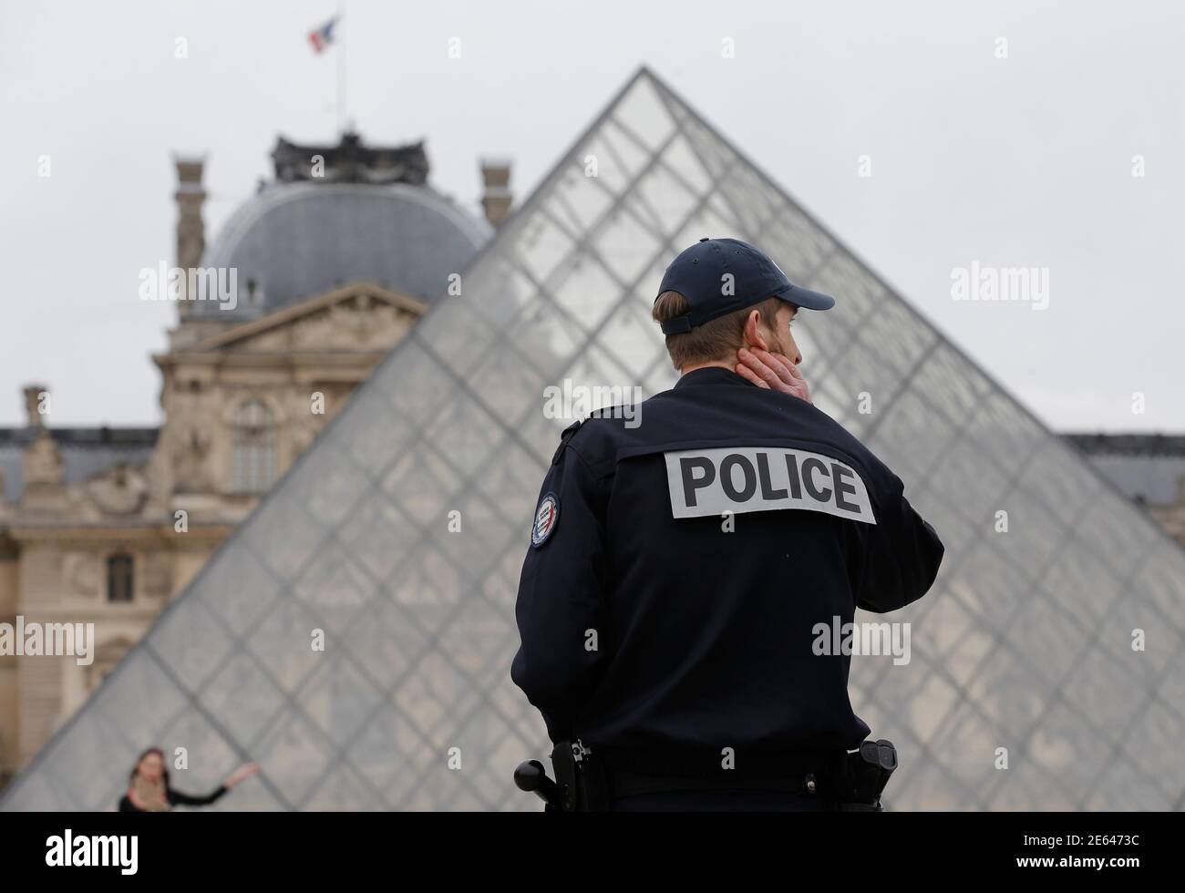 A French police officer patrols next to the Pyramid in the Louvre museum in  Paris April 11, 2013 a day after a one-day closure of the Louvre, as guards  protested that pickpockets