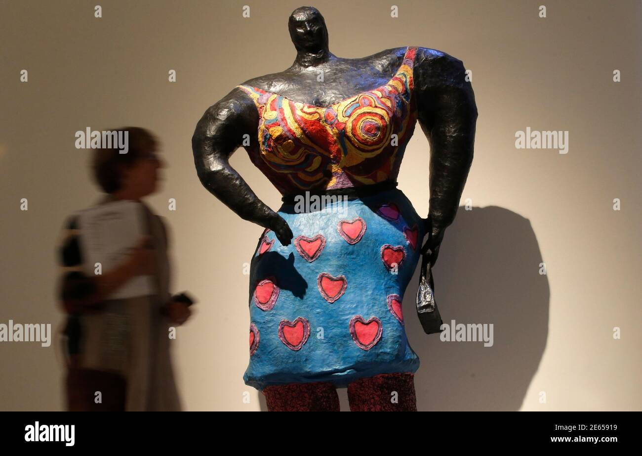 A visitor walks past the sculpture "Black Rosy" by French artist Niki de Saint  Phalle (1930-2002) during an exhibition at the Grand Palais Museum in Paris,  September 16, 2014. Beginning on Wednesday,