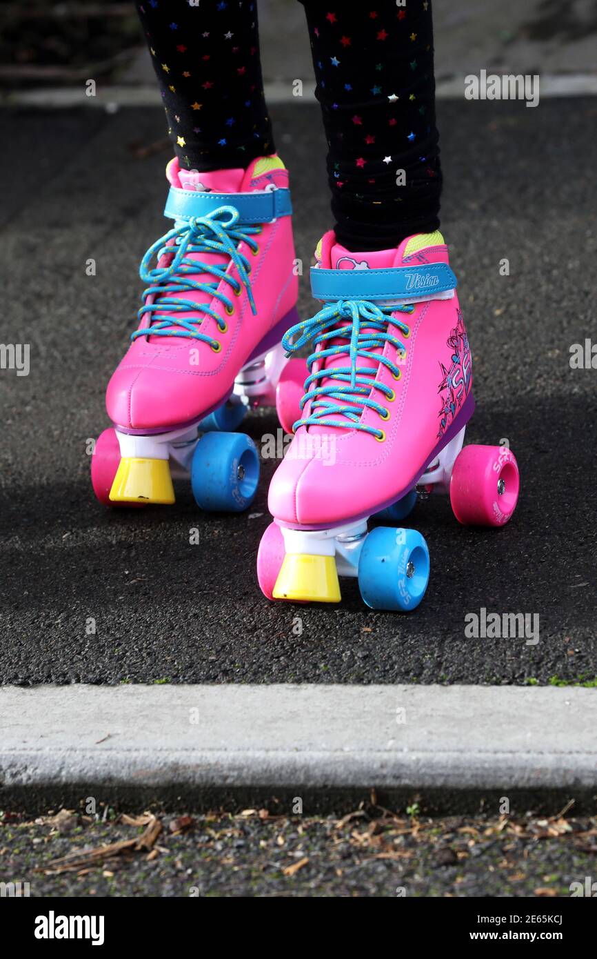 Une jeune fille portant des bottes à roulettes rose vif à Sussex, au Royaume-Uni. Banque D'Images