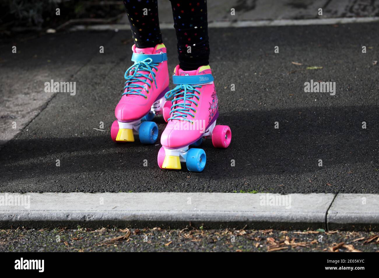 Une jeune fille portant des bottes à roulettes rose vif à Sussex, au Royaume-Uni. Banque D'Images