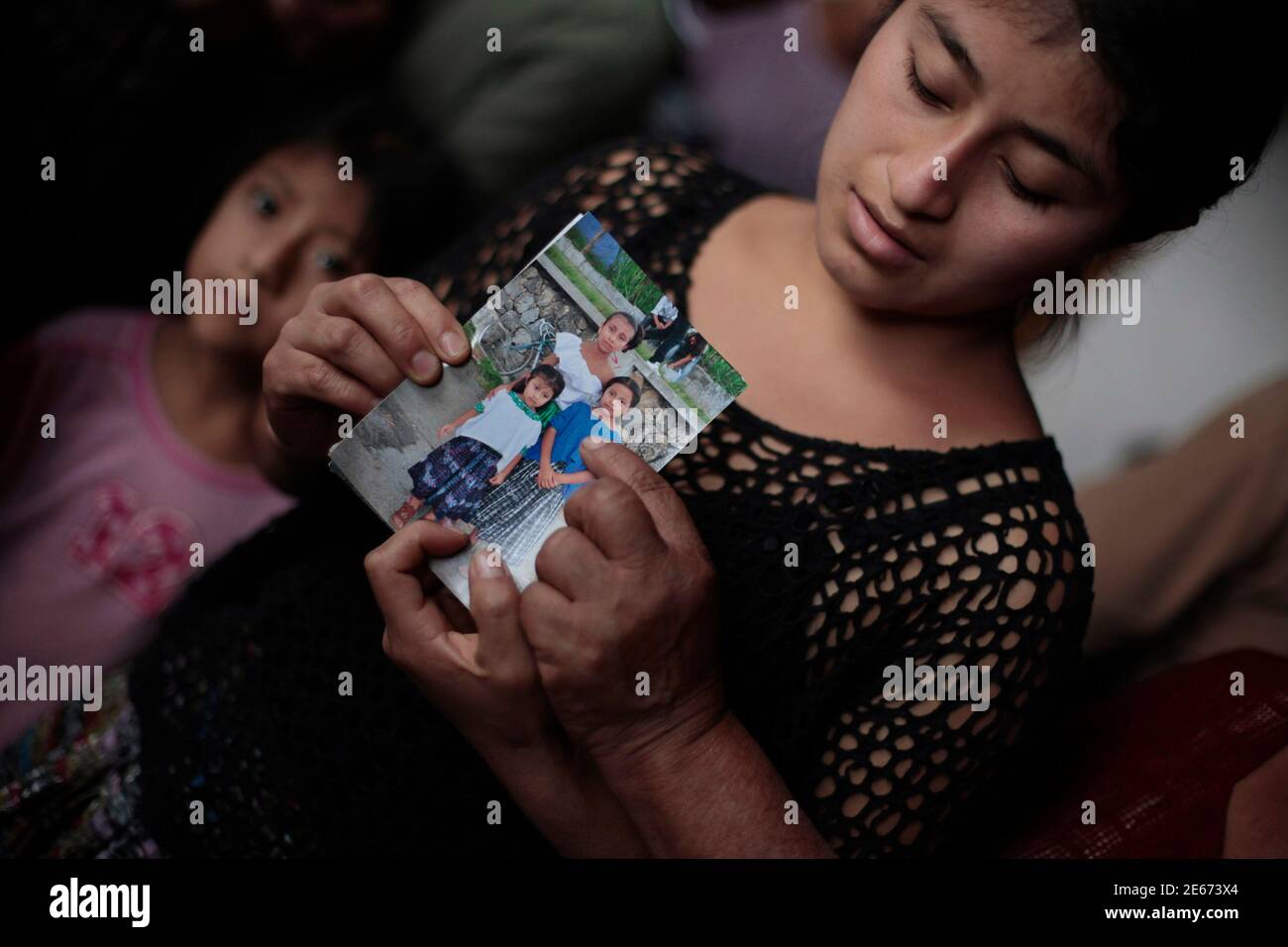 Otilia Bincoy, an aunt of 8-year-old Evelyn Yanisa Saquij Bin who was  killed by a man in a classroom at a primary school, shows a picture of  Evelyn (wearing a blue top)
