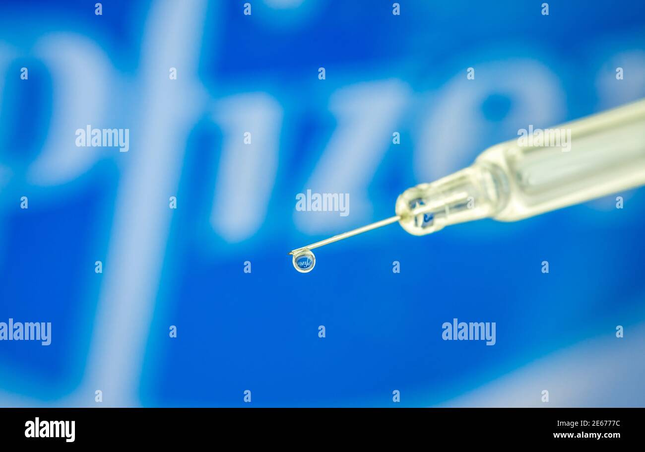Vienne Autriche Jan.28 2021, seringue avec goutte de liquide contre le logo Pfizer est une société pharmaceutique multinationale américaine coronavirus vacci Banque D'Images