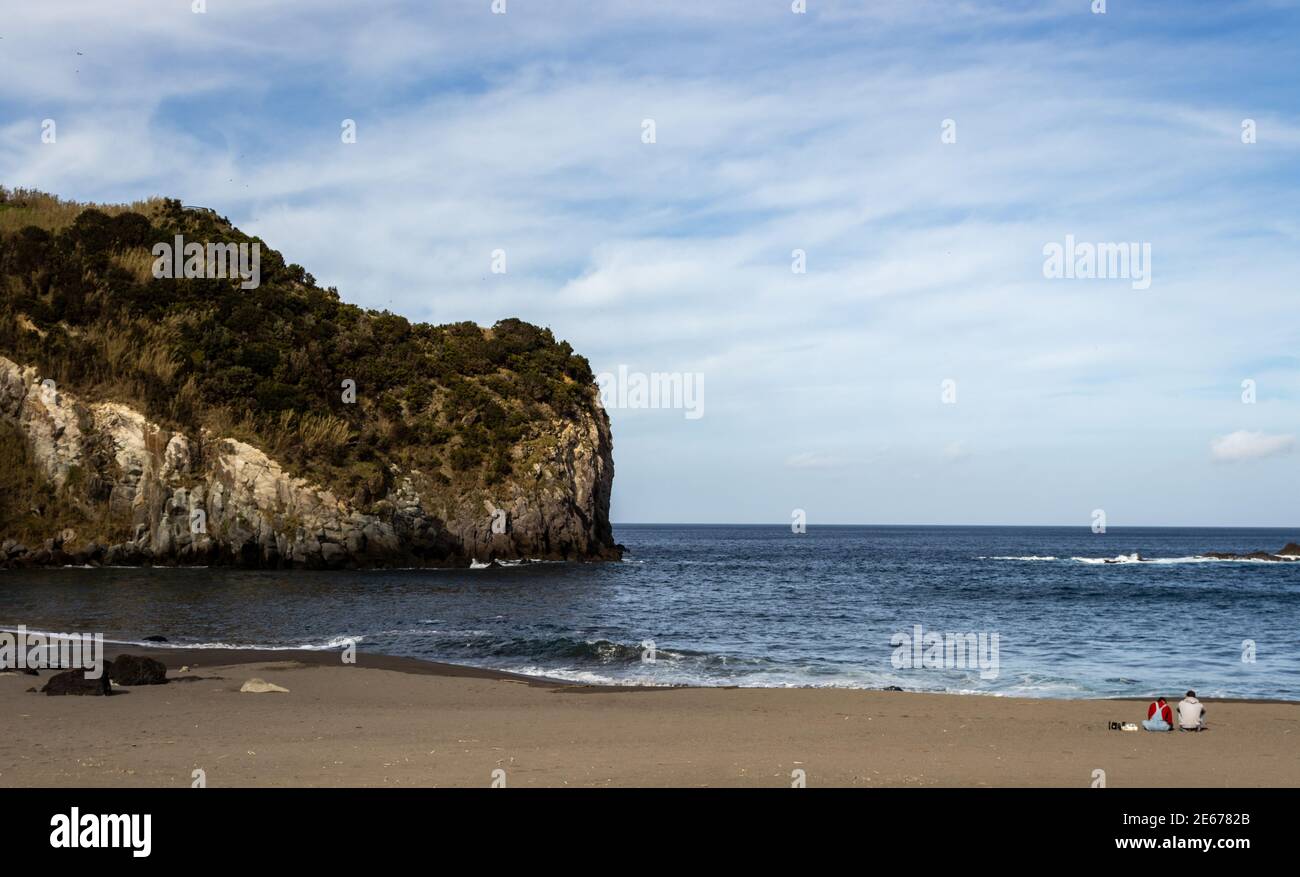 Deux personnes assises sur la plage, amoureux appréciant, beau temps, Açores, Sao Miguel. Banque D'Images