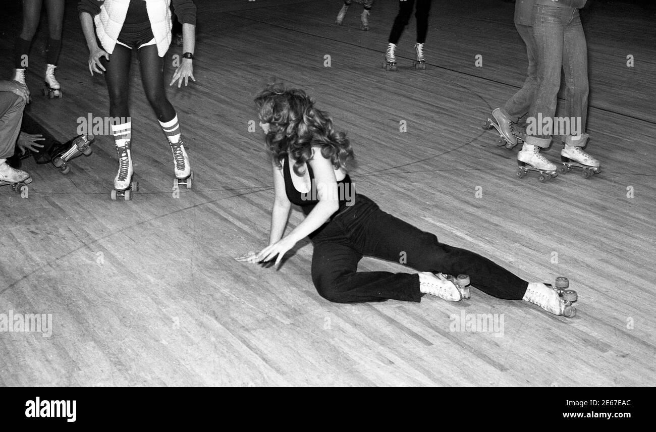 Les patineurs tentent d'éviter une femme qui est tombée sur une patinoire à Los Angeles, CA vers les années 1970 Banque D'Images