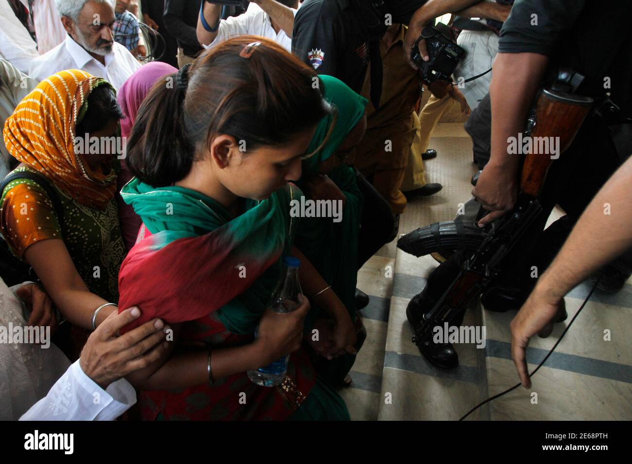 Pakistani security officials escort Poonam (C), a daughter of Sarabjit  Singh, who was convicted of spying for India and sentenced to death in  Pakistan, as she arrives with her family members at
