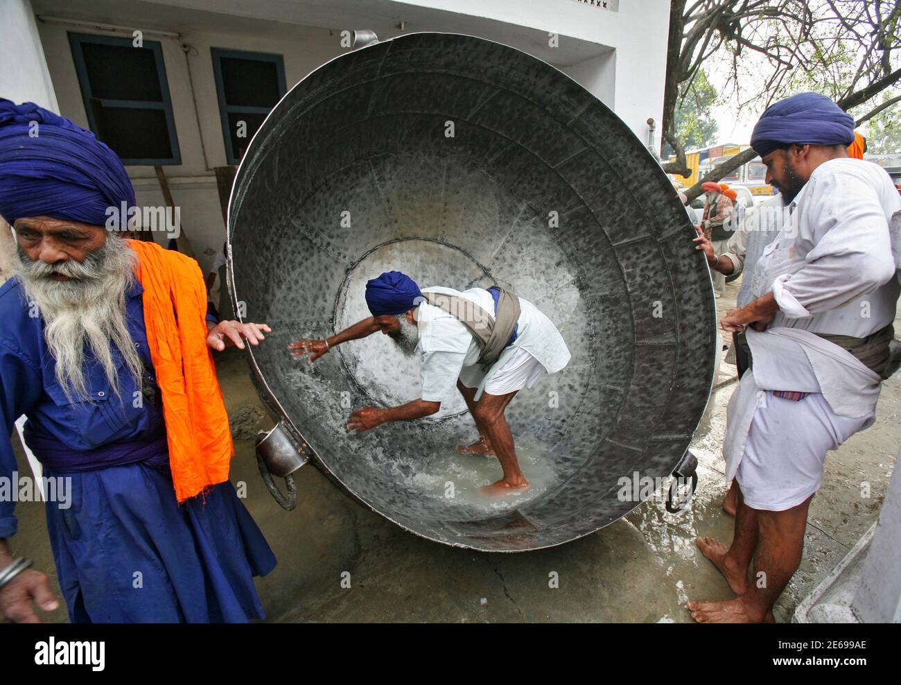 A man cleans a huge pan to prepare a non-alcoholic drink during  celebrations of Hola Mohalla festival at Anandpur Sahib in the northern  Indian state of Punjab March 28, 2013. 