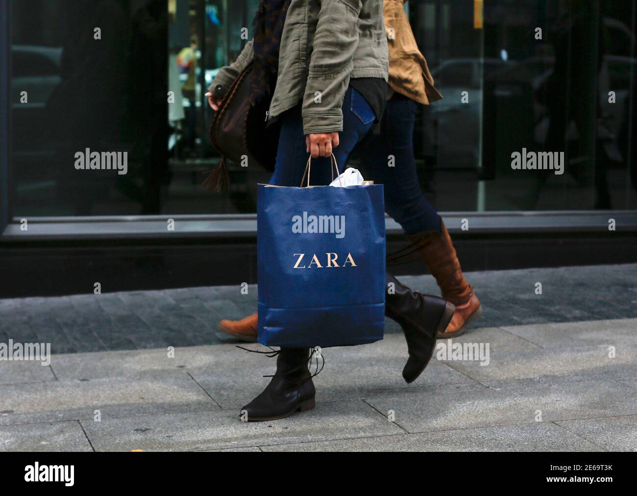 Shoppers leave a Zara store in central Madrid, November 5, 2013. The  world's largest fashion retailer, Inditex, shows no sign of stalling and  investors are betting that its Zara 