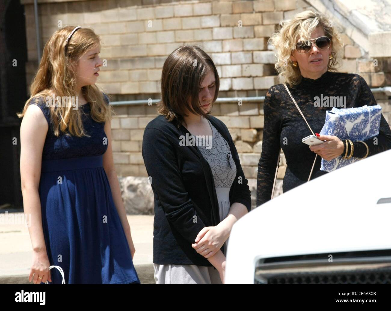 Two daughters of Gordon Cowden and his ex-wife (R) leave his memorial  service at Pathways church in Denver July 25, 2012. The man accused of the  shooting rampage in a Denver-area screening