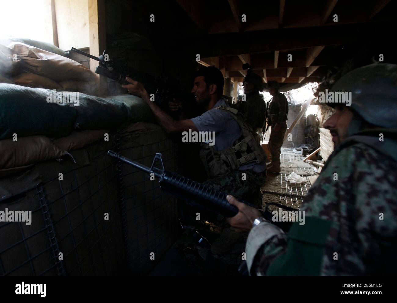 Les soldats de l'Armée nationale afghane ont tiré leurs fusils lors d'une bataille d'incendie entre les combattants talibans et les soldats afghans et américains du 2e peloton, compagnie Charlie, 2e bataillon, 27e Régiment d'infanterie à Checkpoint Two point Five dans la province de Kunar le 14 juillet 2011. REUTERS/Baz Ratner (AFGHANISTAN - Tags: CONFLIT MILITAIRE) Banque D'Images