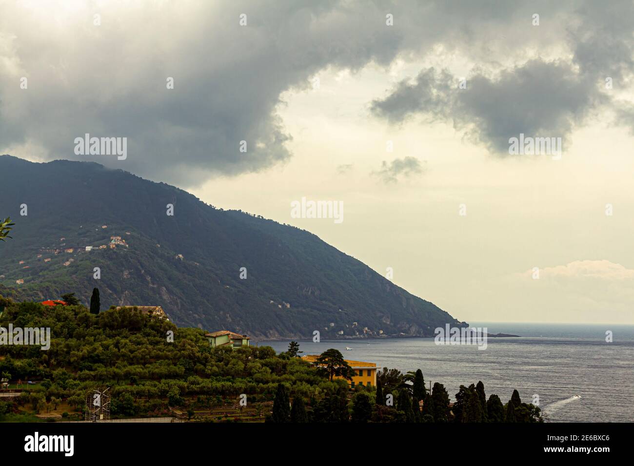 Vue sur la colline de la côte ligure de l'Italie entre Gênes et Cinque Terra. Il y a des maisons de villa sur la côte rocheuse couvertes de maquis et d'arbres o Banque D'Images