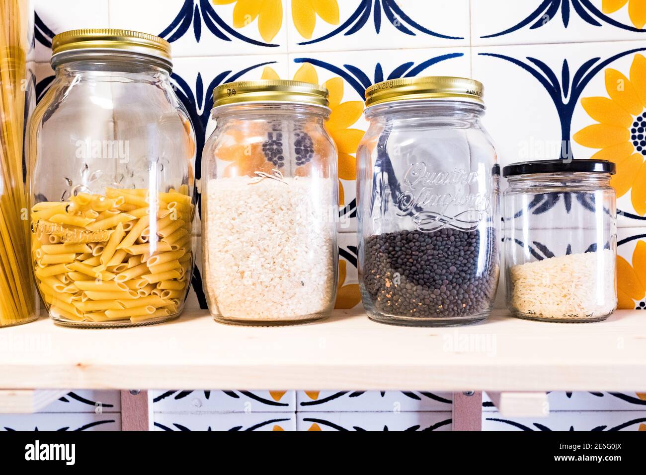 Étagère en bois dans une cuisine avec pots en verre avec vrac pâtes et riz Banque D'Images