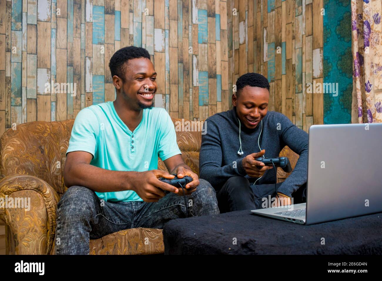 jeunes hommes noirs jouant à un jeu vidéo sur un ordinateur portable à la maison Banque D'Images