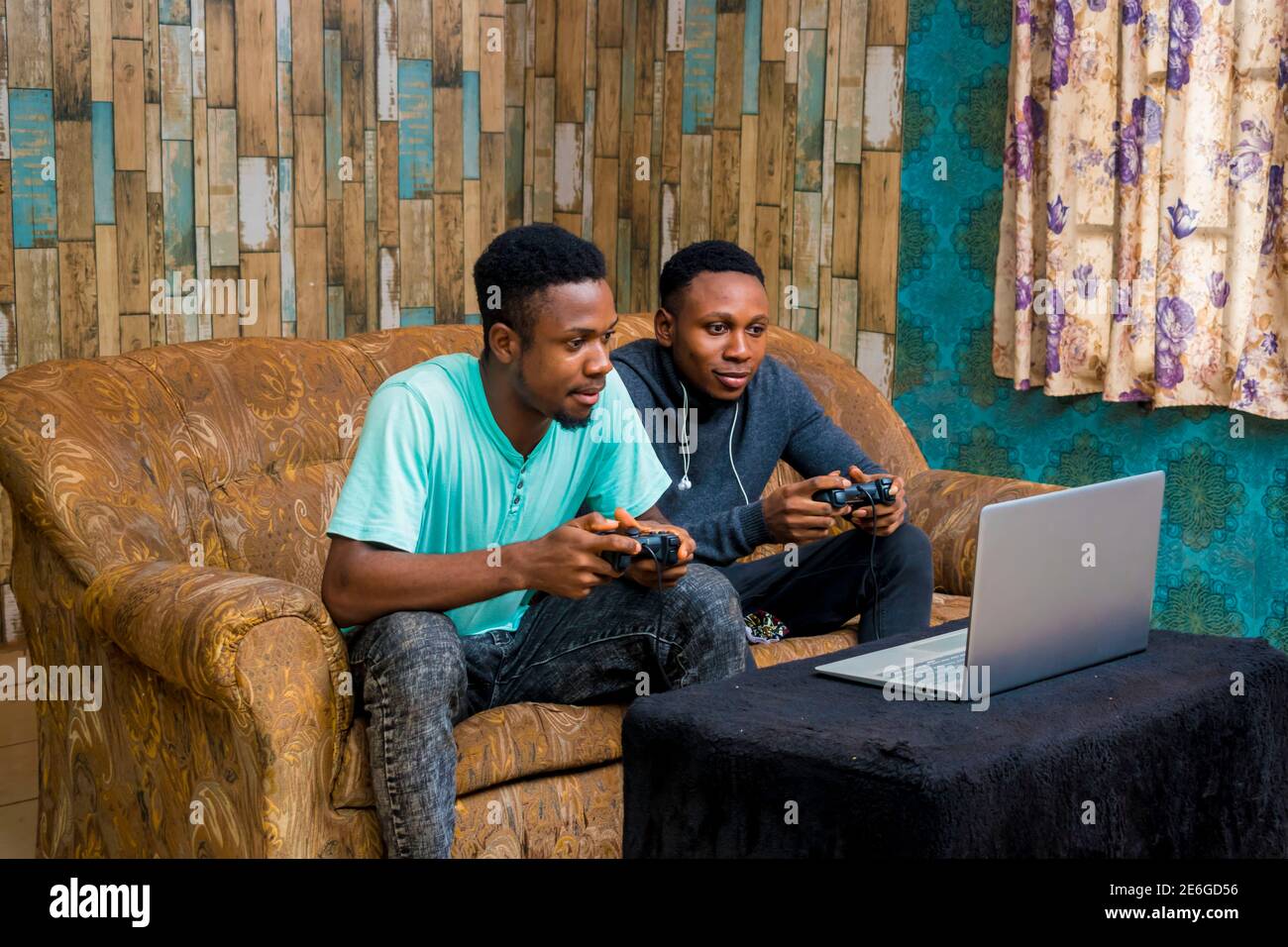 jeunes hommes noirs jouant à un jeu vidéo sur un ordinateur portable à la maison Banque D'Images