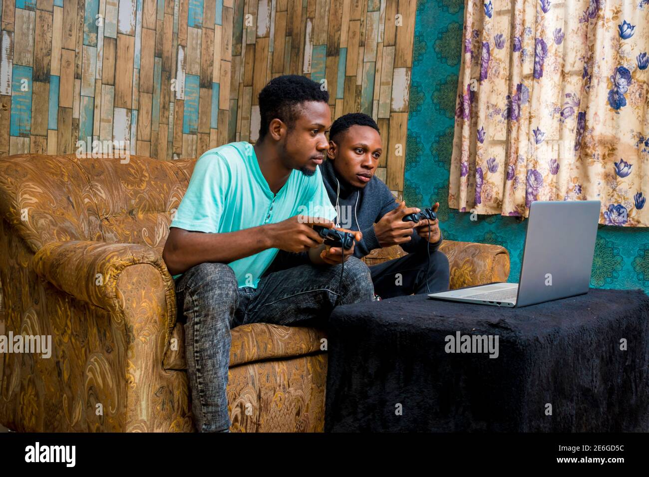 jeunes hommes noirs jouant à un jeu vidéo sur un ordinateur portable à la maison Banque D'Images