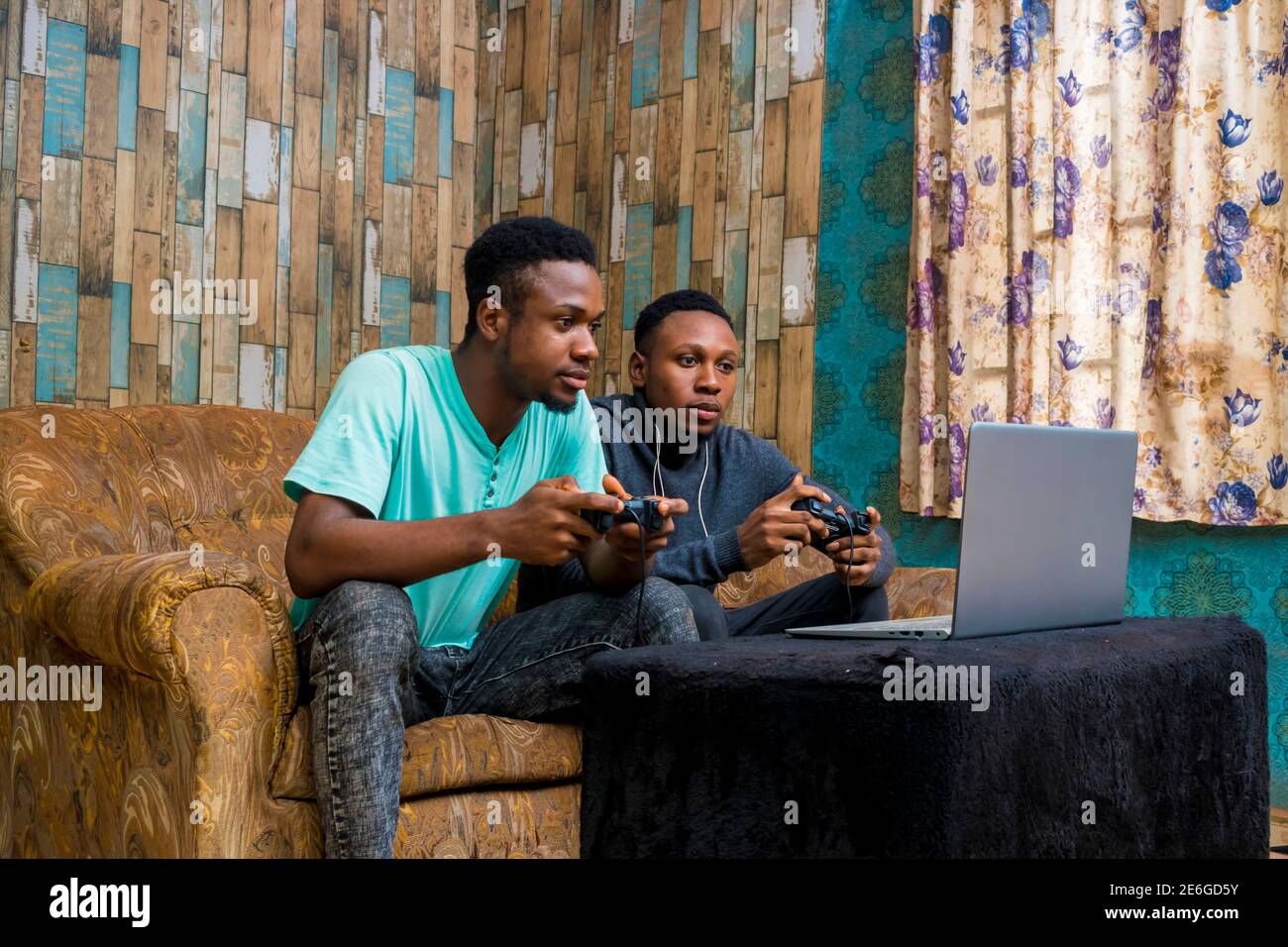 jeunes hommes noirs jouant à un jeu vidéo sur un ordinateur portable à la maison Banque D'Images