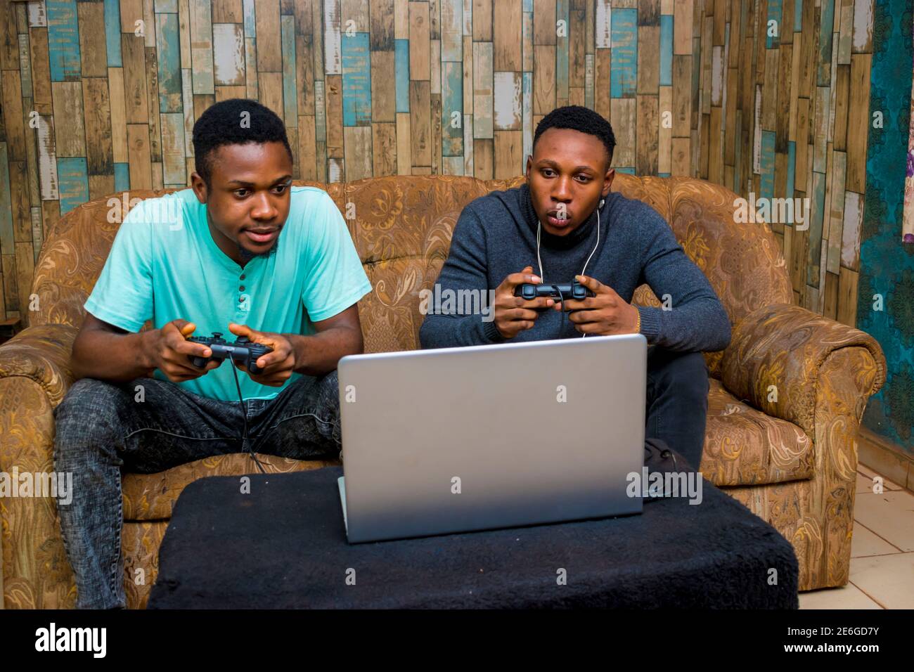 jeunes hommes noirs jouant à un jeu vidéo sur un ordinateur portable à la maison Banque D'Images