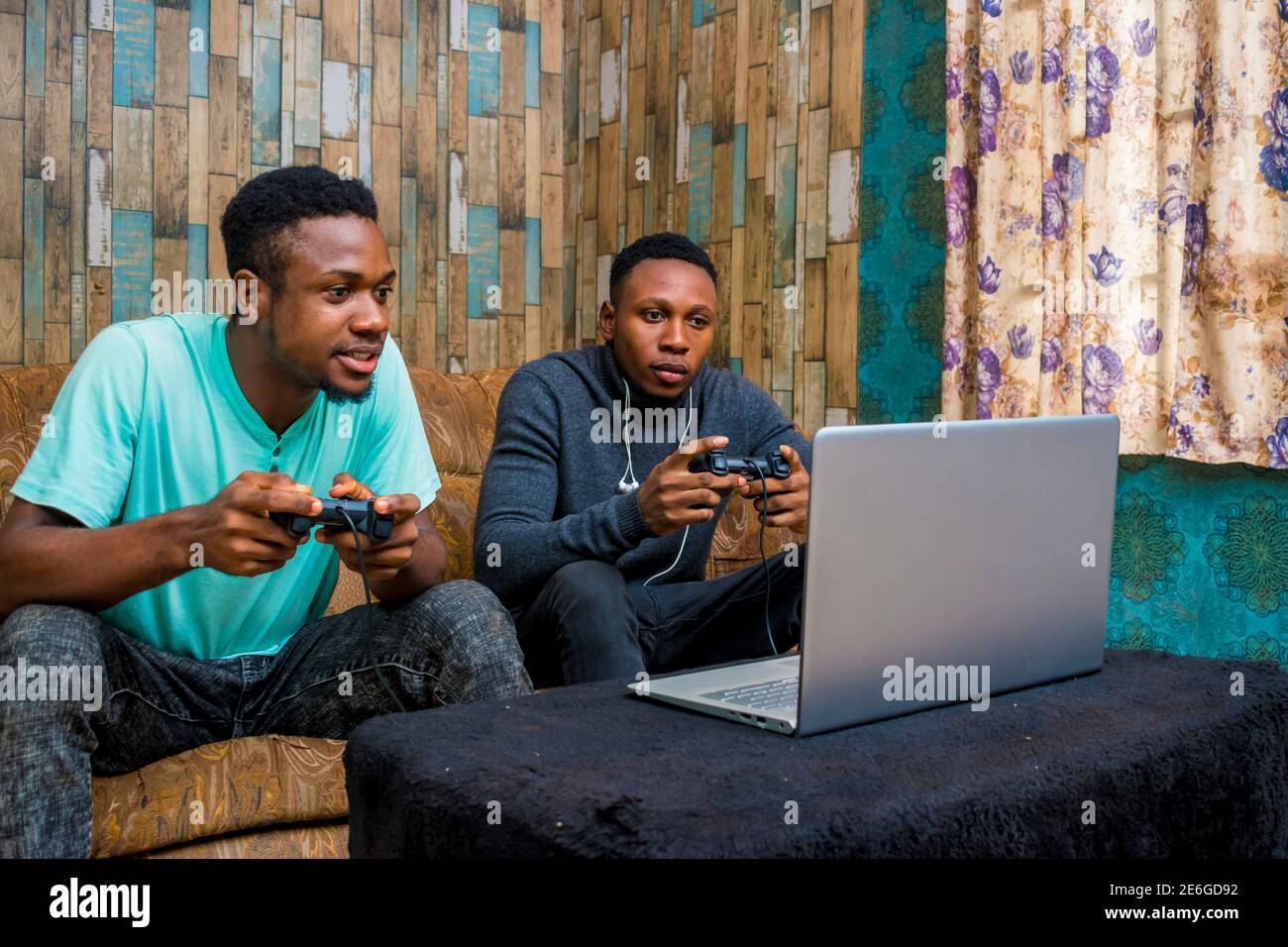 jeunes hommes noirs jouant à un jeu vidéo sur un ordinateur portable à la maison Banque D'Images