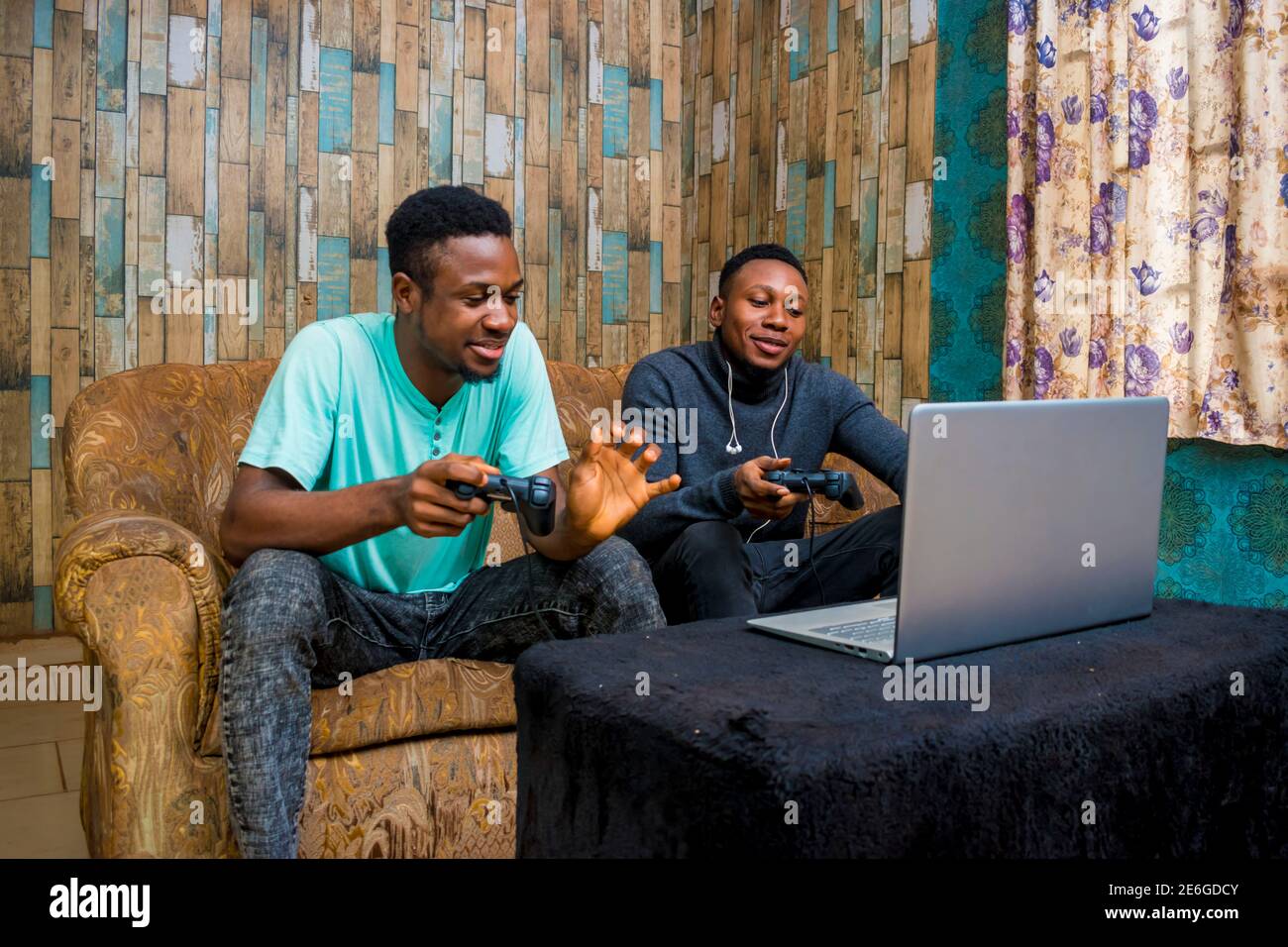 jeunes hommes noirs jouant à un jeu vidéo sur un ordinateur portable à la maison Banque D'Images