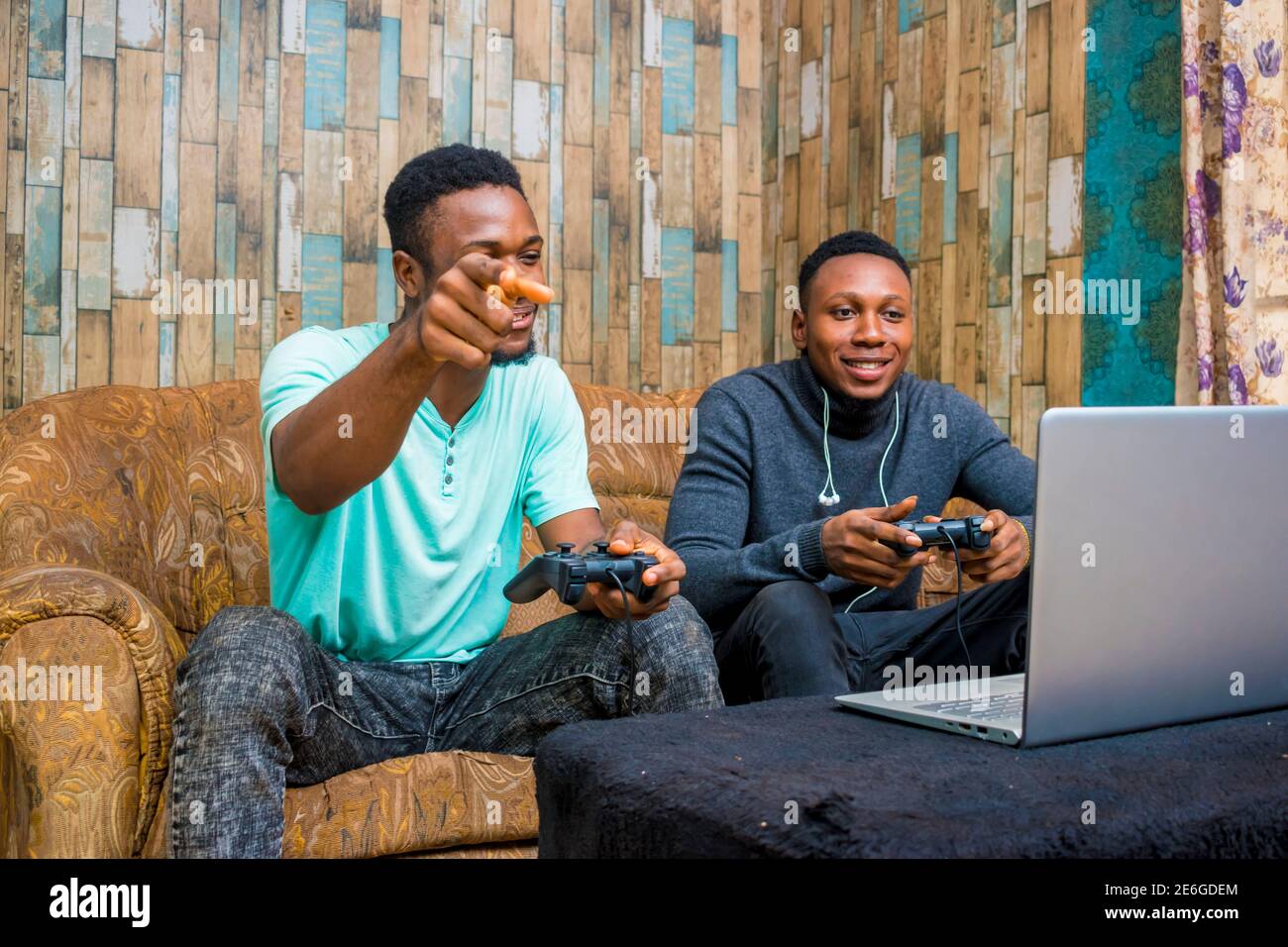 jeunes hommes noirs jouant à un jeu vidéo sur un ordinateur portable à la maison Banque D'Images
