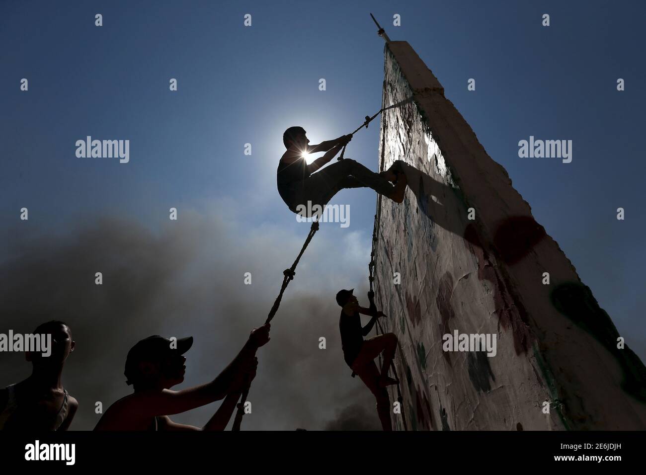 De jeunes Palestiniens montent un mur avec une corde lors d'un exercice de style militaire dans un camp d'été organisé par le mouvement du Jihad islamique, à Khan Younis, dans le sud de la bande de Gaza, le 13 août 2015. REUTERS/Ibraheem Abu Mustafa Banque D'Images