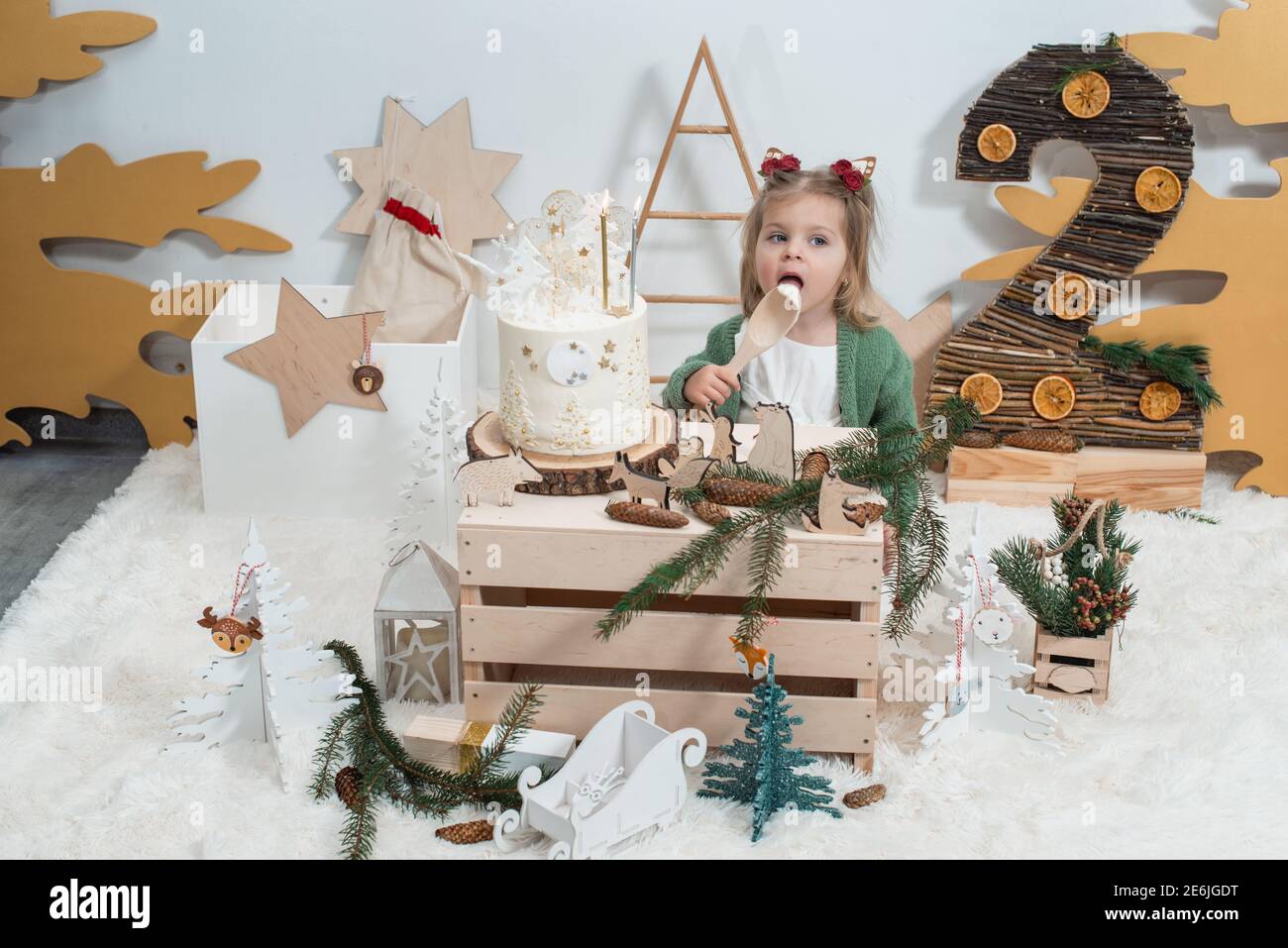 Decorations D Anniversaire D Hiver Pour Enfants 2 Ans Jolie Petite Fille Dans Un Gilet Vert Pres D Un Gateau D Anniversaire Blanc Photo Stock Alamy