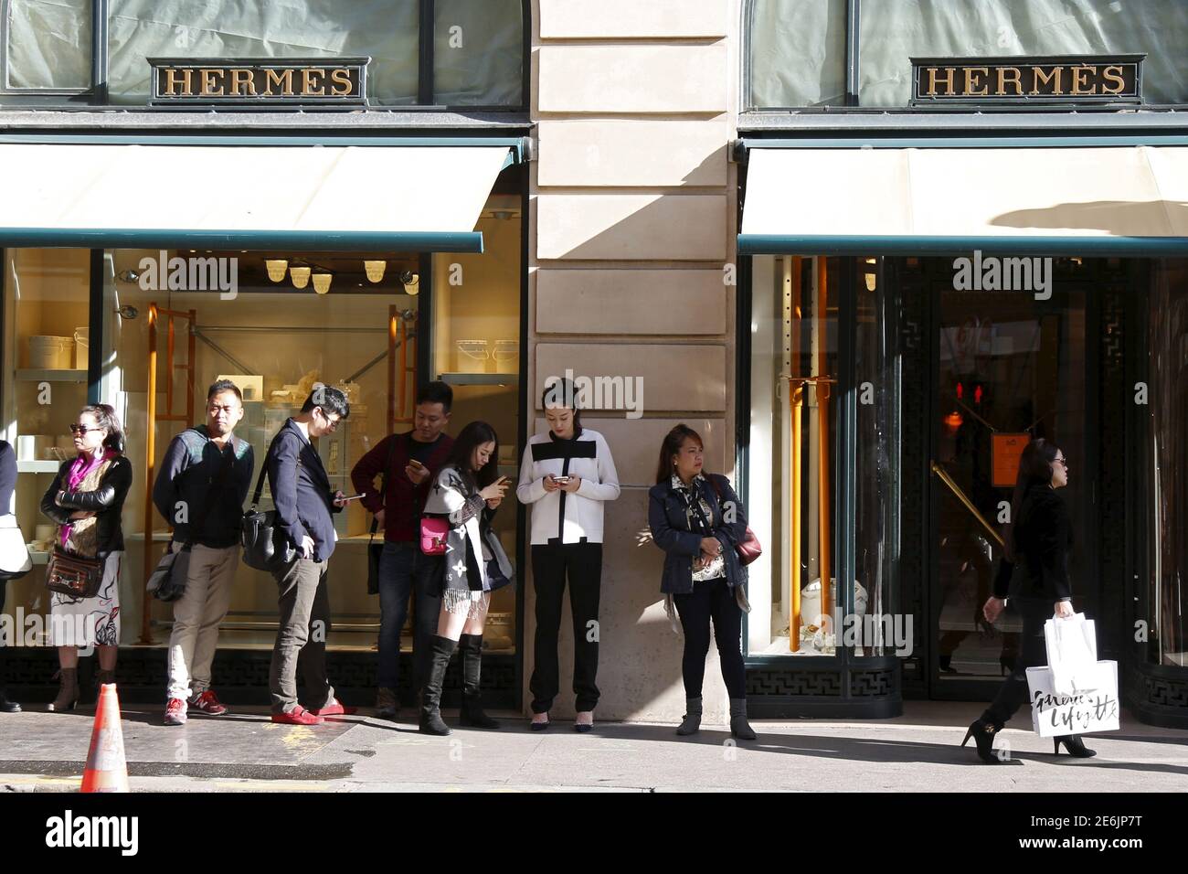 Les clients attendent l'ouverture du magasin principal du groupe de luxe  français Hermes à Paris, France, le 23 septembre 2015. Les consommateurs  chinois de luxe dépensent davantage en prêt-à-porter et en nouvelles