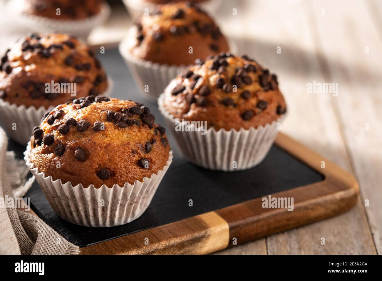 Des muffins au chocolat juste sortis du four sur une table en bois Banque D'Images