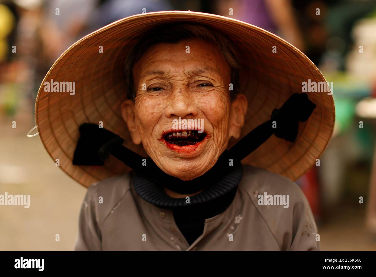 Une femme portant un chapeau traditionnel, connu sous le nom de non la,  pose pour un portrait sur un marché à Hoi an, Vietnam le 5 avril 2016. Les  chapeaux non à
