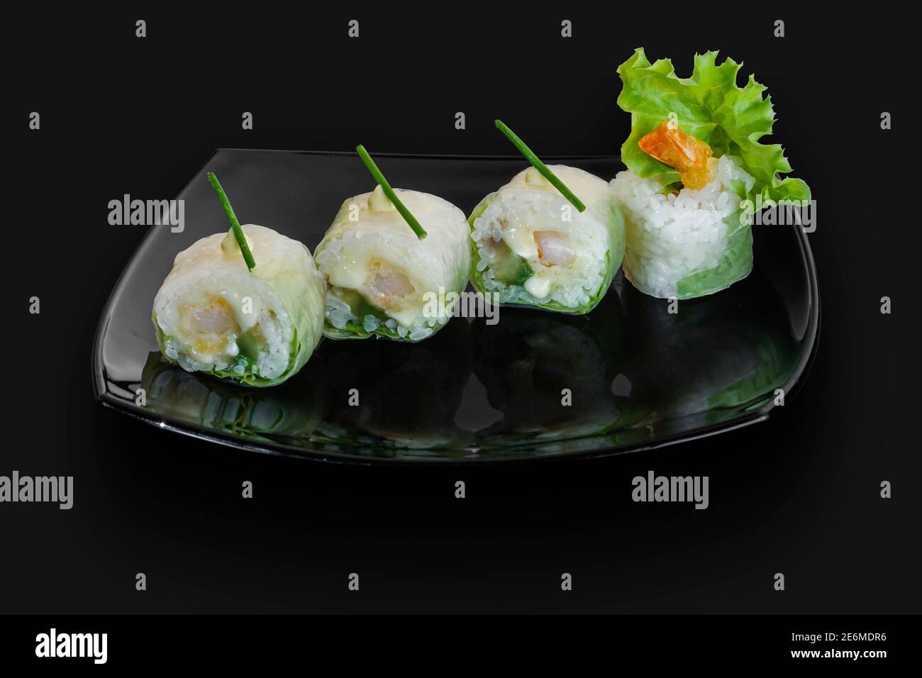 Des petits pains à sushis japonais fraîchement préparés sont servis sur une pierre noire Des petits pains à sushis japonais fraîchement préparés sont servis sur un plat noir dalle de pierre Banque D'Images