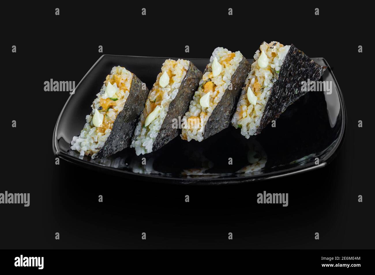 Sandwich de sushis japonais fraîchement confectionnés servi dans un noir plaque Banque D'Images